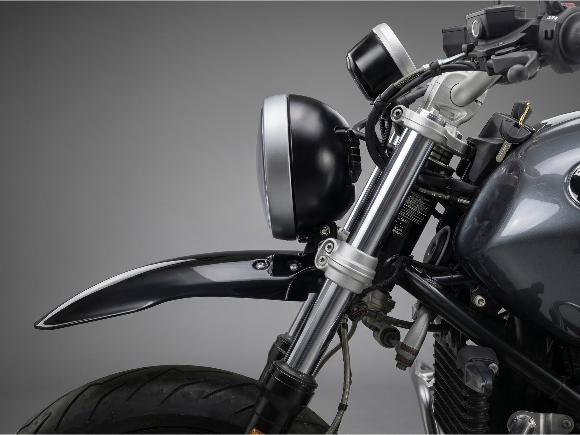 Close-up of a bmw r ninet headlight with a dark background custom front fender kit