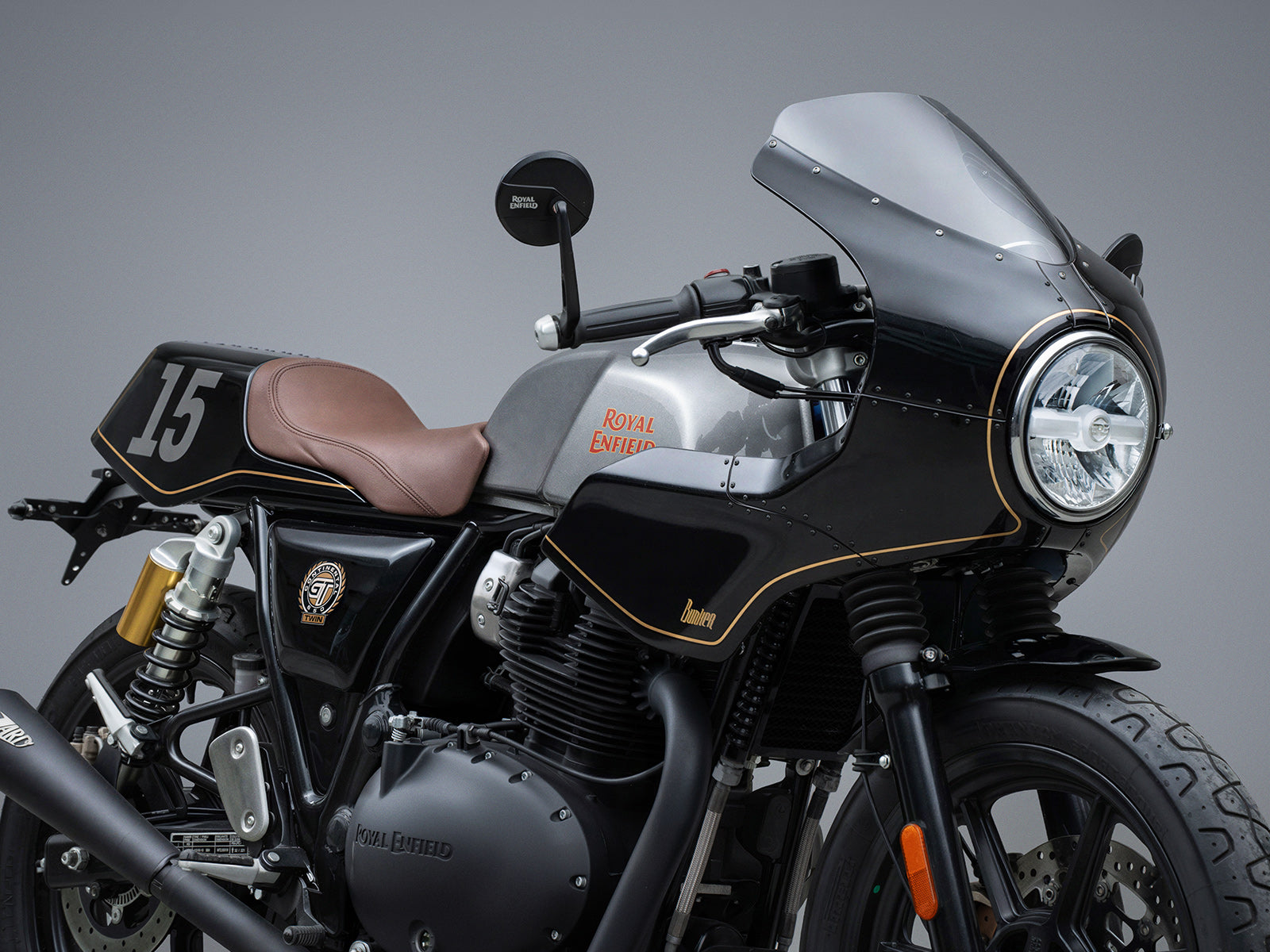 Black Royal Enfield motorcycle with Cafe racer front Fairing Kit  with brown seat on a gray background